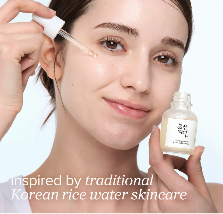 Woman applying a skincare product inspired by traditional Korean rice water skincare.