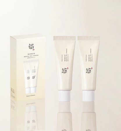 Three skincare products with a box on a light beige background